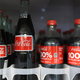 Coca-Cola bottles are shown in a cooler.